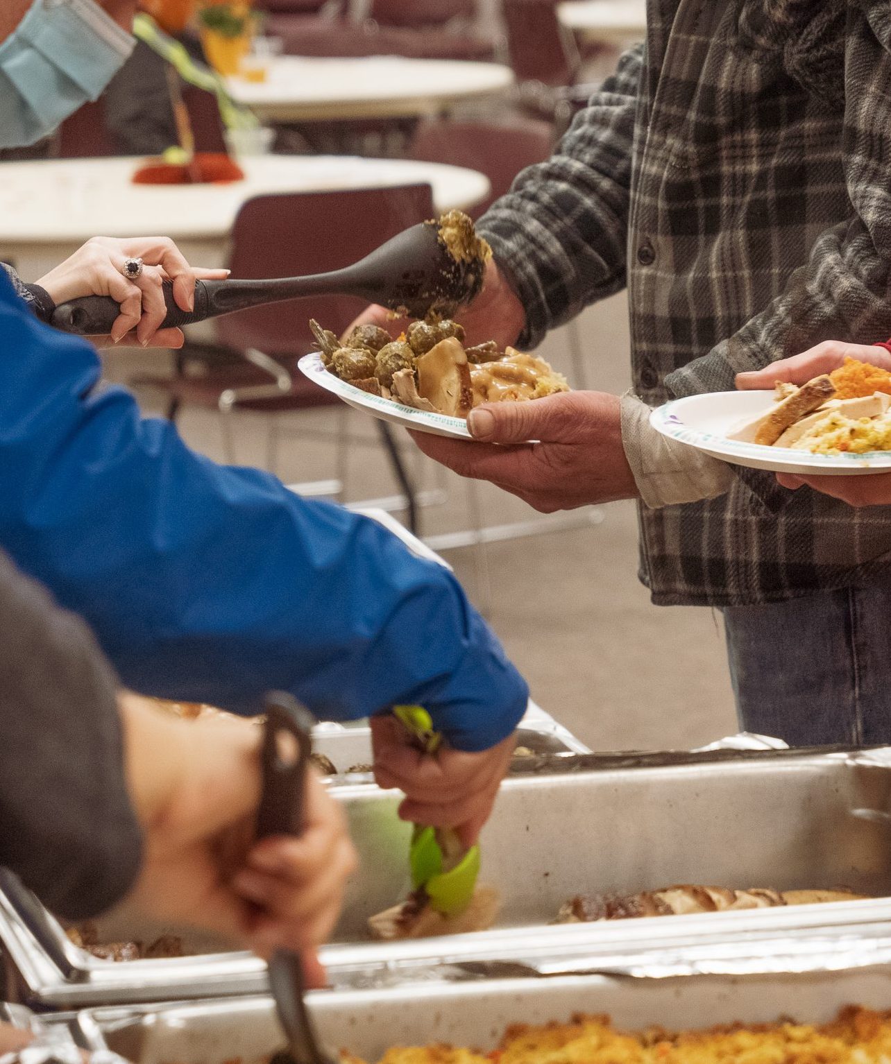 Faceless photo of three people being served a buffet dinner